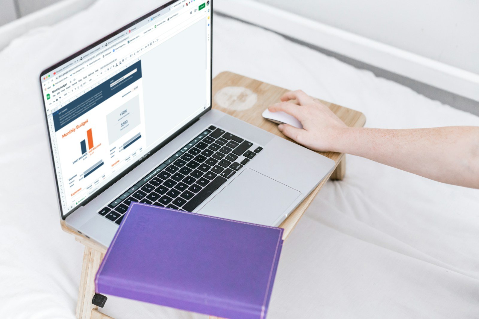 a person sitting on a bed with a laptop